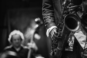 A black and white shot of a man playing jazz on a saxophone
